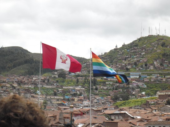 The Peru flag is on the left. The Cusco flag is on the right. The rainbow flag flies over all the government buildings.